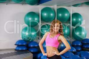 Girl poses on backdrop of stand with fitness balls