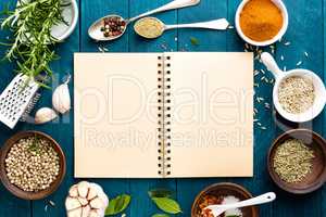 culinary background and recipe book with various spices on wooden table