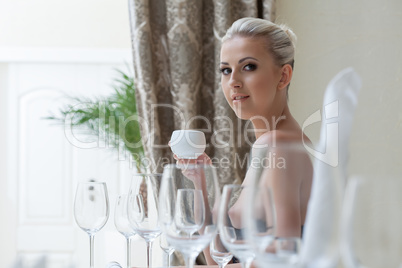 Nude blonde has breakfast in restaurant