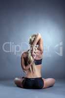 Rear view of flexible blonde woman engaged in yoga