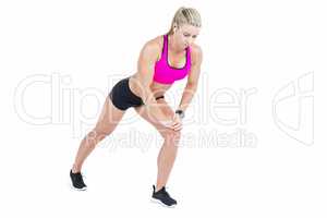 Female athlete stretching and listening music