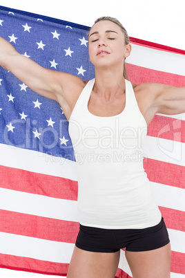 Female athlete holding American flag with closed eyes