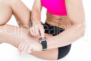 Female athlete sitting and using her smart watch