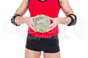 Female athlete with elbow pad holding handball