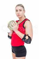 Female athlete with elbow pad holding handball