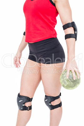 Female athlete with elbow pad holding handball