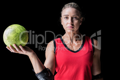 Female athlete with elbow pad holding handball