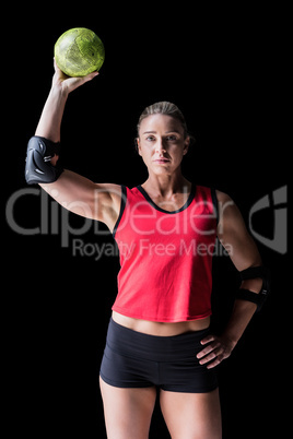 Female athlete with elbow pad holding handball