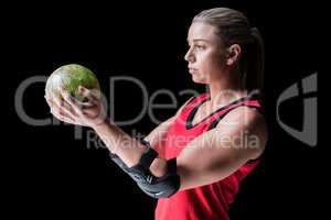 Female athlete with elbow pad holding handball