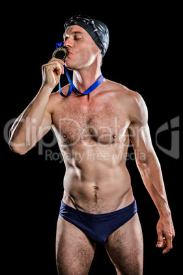 Swimmer kissing his gold medal