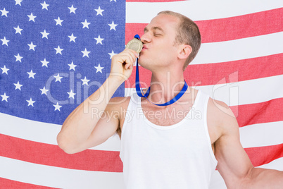 Close-up of athlete kissing medal