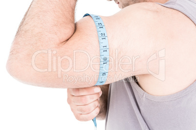 Close-up of athlete measuring his biceps with measuring tape