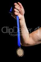 Hand holding olympic gold medal
