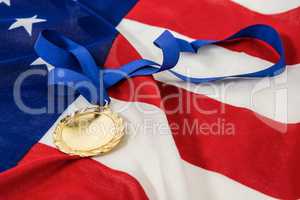Close-up of gold medal on american flag
