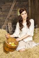 Young country woman with a fruit basket in the barn