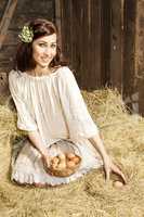 Young country woman with egg basket in the barn