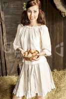 Young country woman with egg basket in the barn