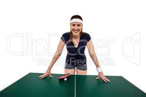 Happy female athlete leaning on hard table