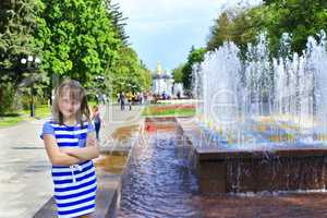 modern young girl has a rest in the city park with fountains