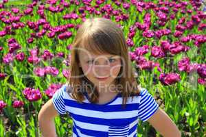 little girl stand by lilac tulips