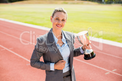 Portrait of happy businesswoman holding a trophy