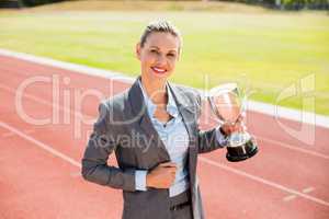 Portrait of happy businesswoman holding a trophy