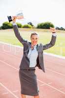 Portrait of happy businesswoman holding up a trophy