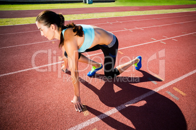 Confident female athlete in ready to run position