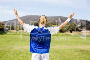 Rear view of female football player posing after a victory
