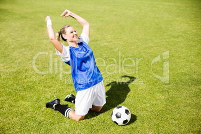 Excited football player kneeling in stadium