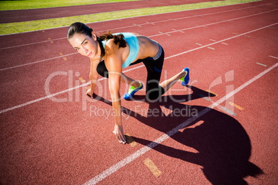 Portrait of female athlete in ready to run position
