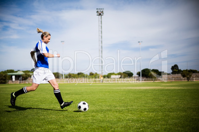 Female football player practicing soccer