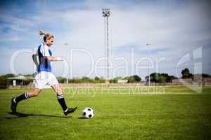 Female football player practicing soccer