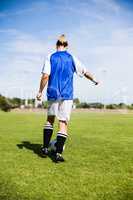 Rear view of female football player practicing soccer