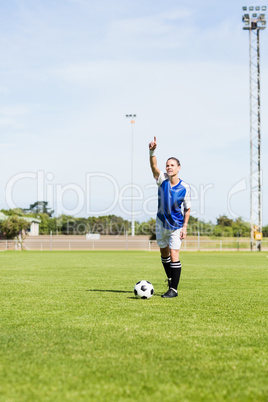 Female football player gesturing while playing football