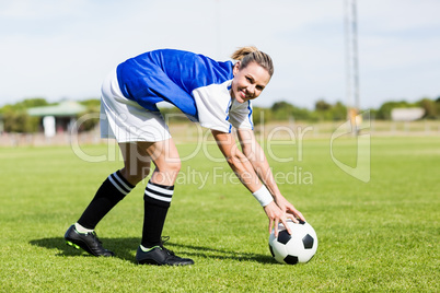 Portrait of female football player keeping a ball