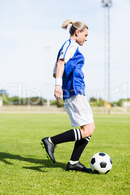 Female football player practicing soccer Female football player practicing soccer