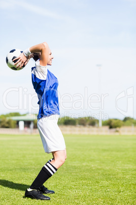 Female football player about to throw a football