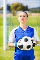 Female goalkeeper standing with ball