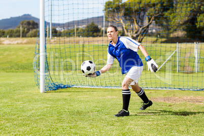 Female goalkeeper about to throw a football