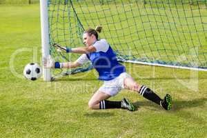 Female goalkeeper saving a goal