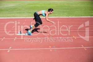 Female athlete running from starting blocks
