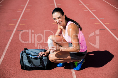 Portrait of happy female athlete with her sports accessories