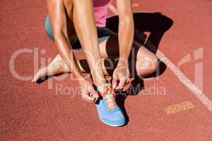 Female athlete tying her running shoes