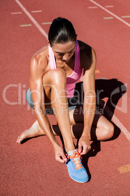 Female athlete tying her running shoes