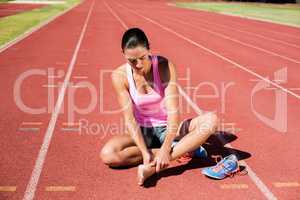 Female athlete with foot pain on running track