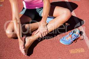 Female athlete with foot pain on running track