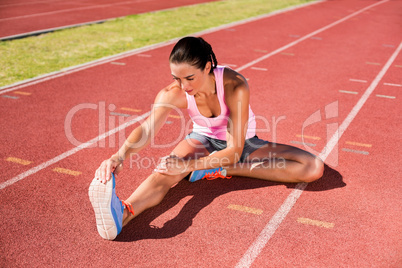 Female athlete stretching her hamstring