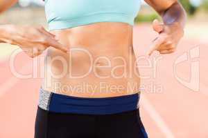 Mid section of female athlete pointing on her belly