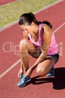 Female athlete tying her running shoes